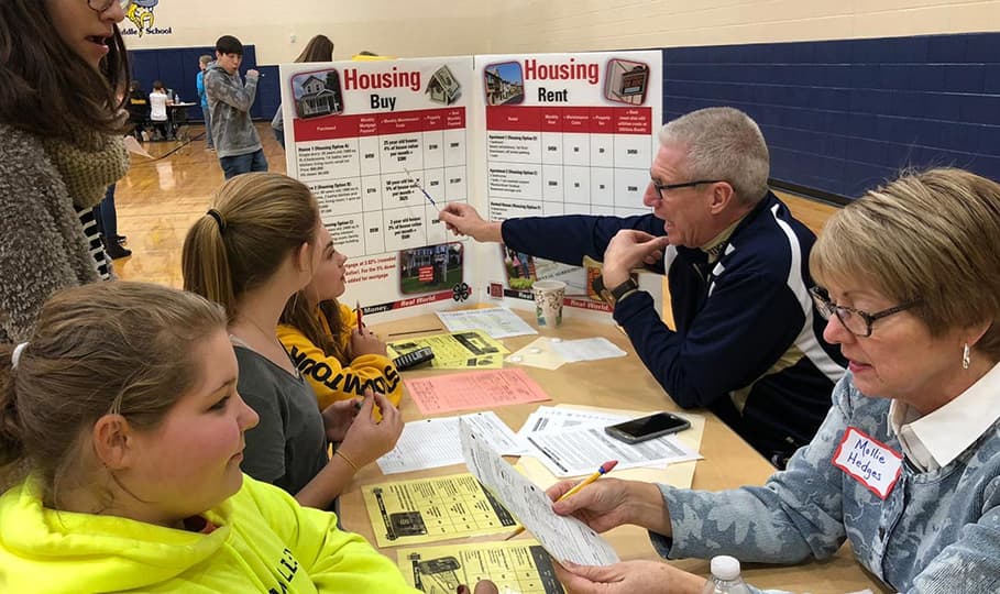 A community volunteer helping a student during Real Money Real World